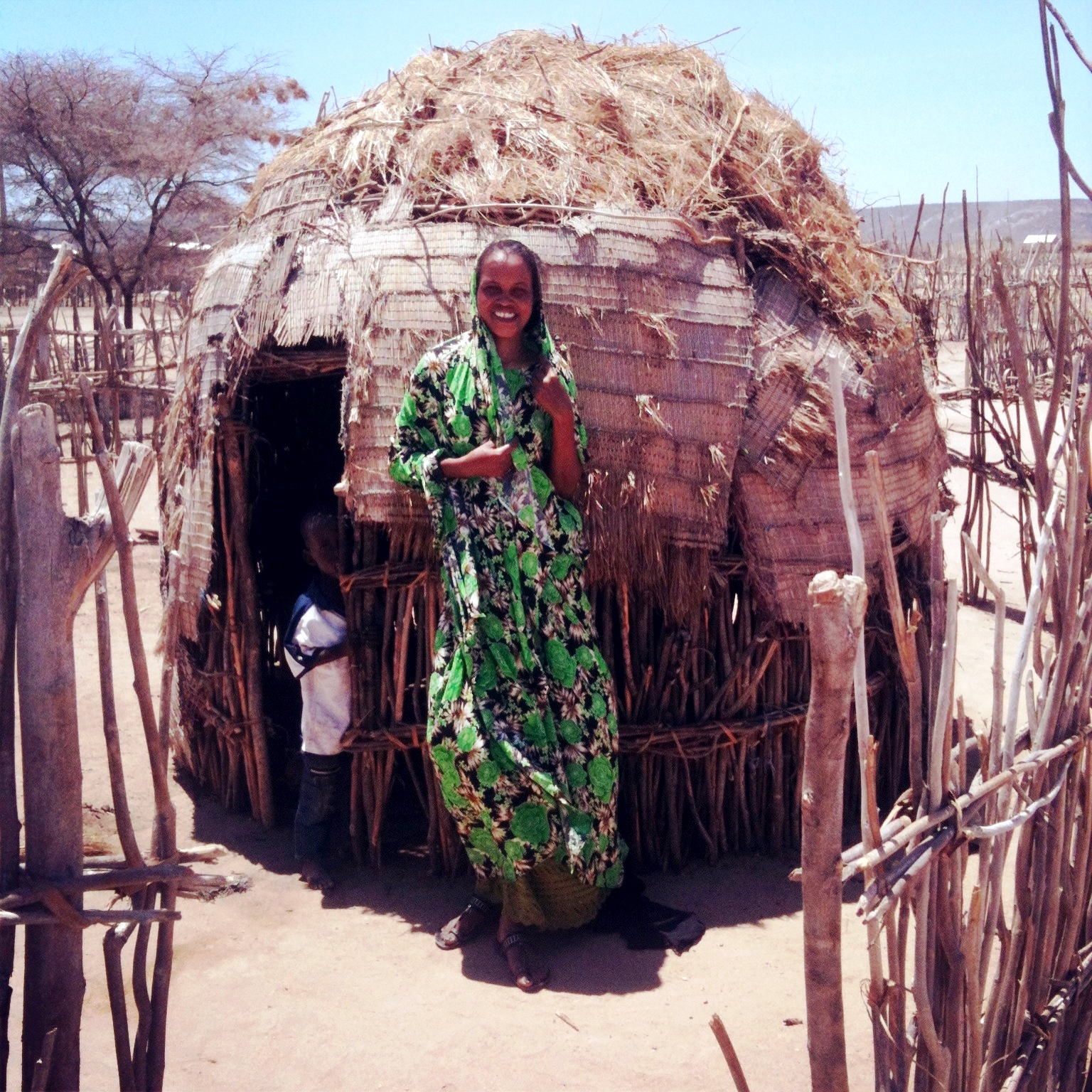 Woman in front of a manyatta (a Masai or Samburu settlement)