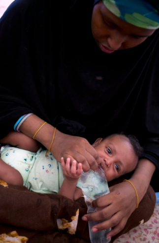 Exclusive breastfeeding is a critical but elusive practice. Here, eighteen year old refugee, Kowsar Ahmed Hussein, gives one month old Jamal water to drink at a WFP transit camp in Bossaso, Puntland, Somalia.