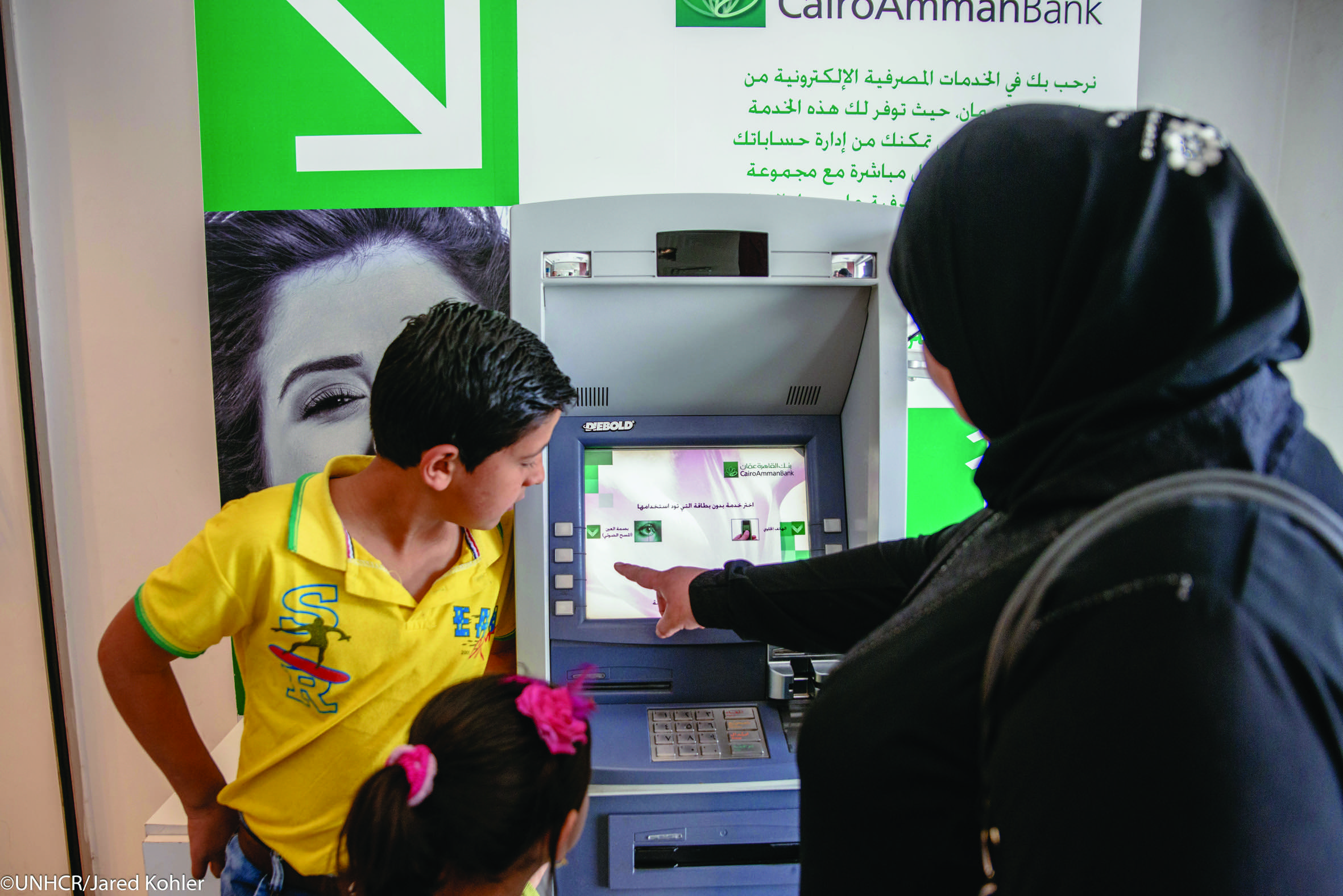 Syrian refugee using iris scan technology to withdraw monthly cash assistance, Amman, Jordan.