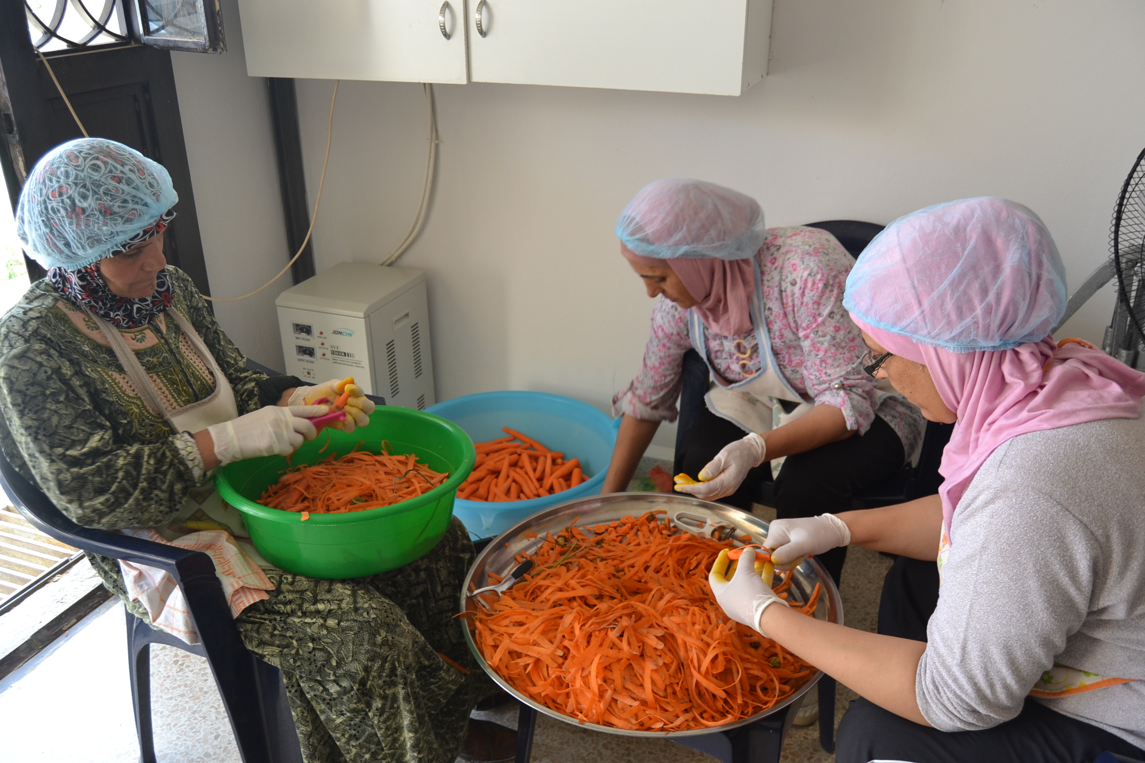 Syrian and Lebanese women work together to prepare food in the community kitchen project