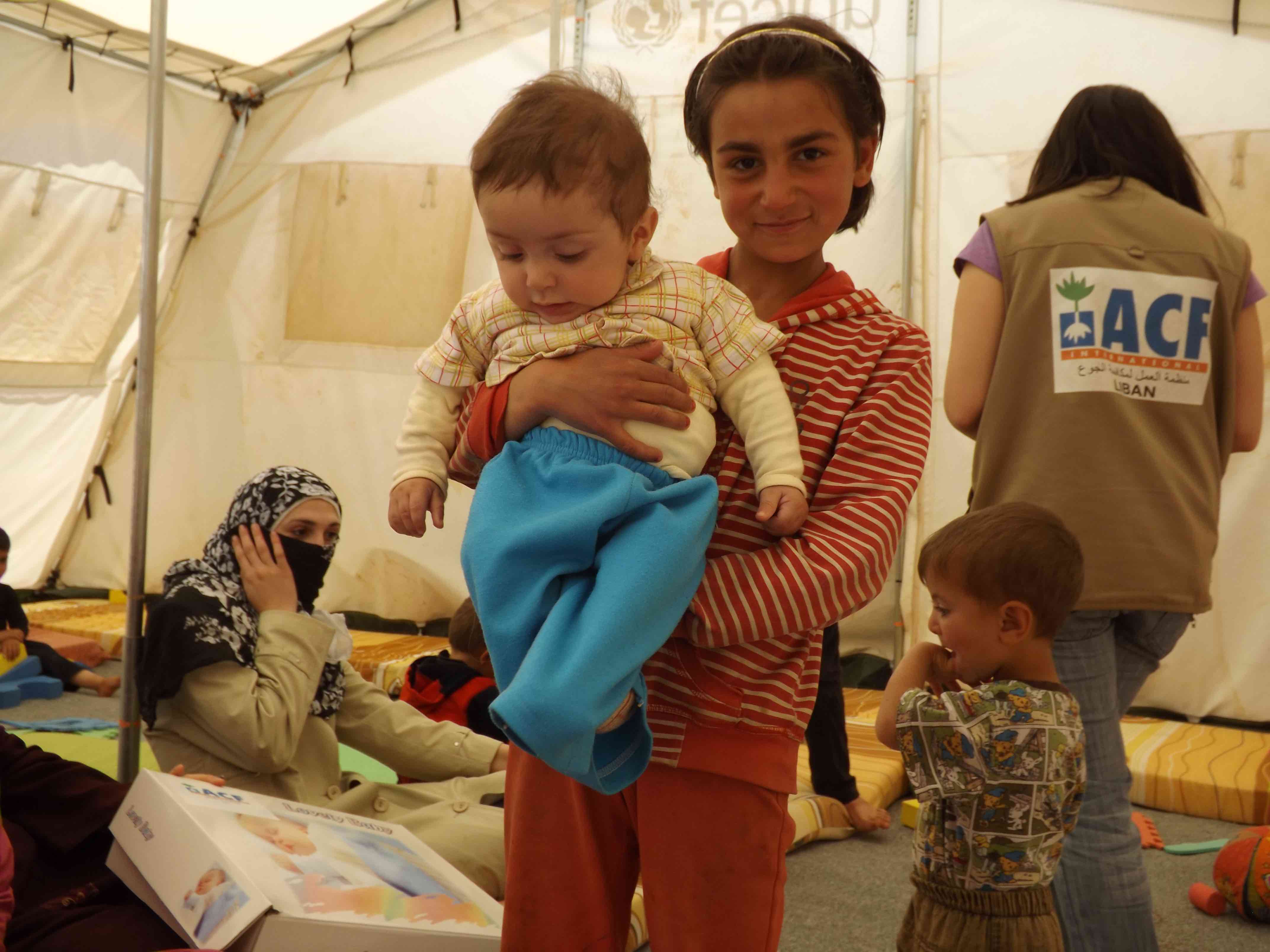 In the ACF tent in Aarsal, Syrian refugees receive support and baby kits with essential items for their children: soap, blanket, baby spoon and cup