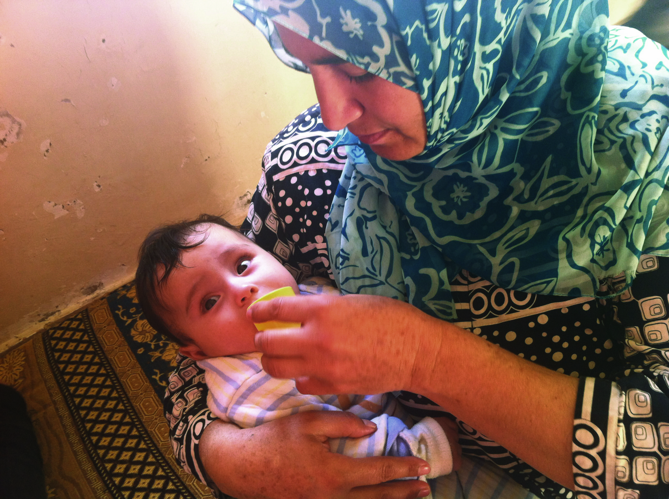 After receiving individual counselling, a woman is cup feeding her child with expressed breastmilk