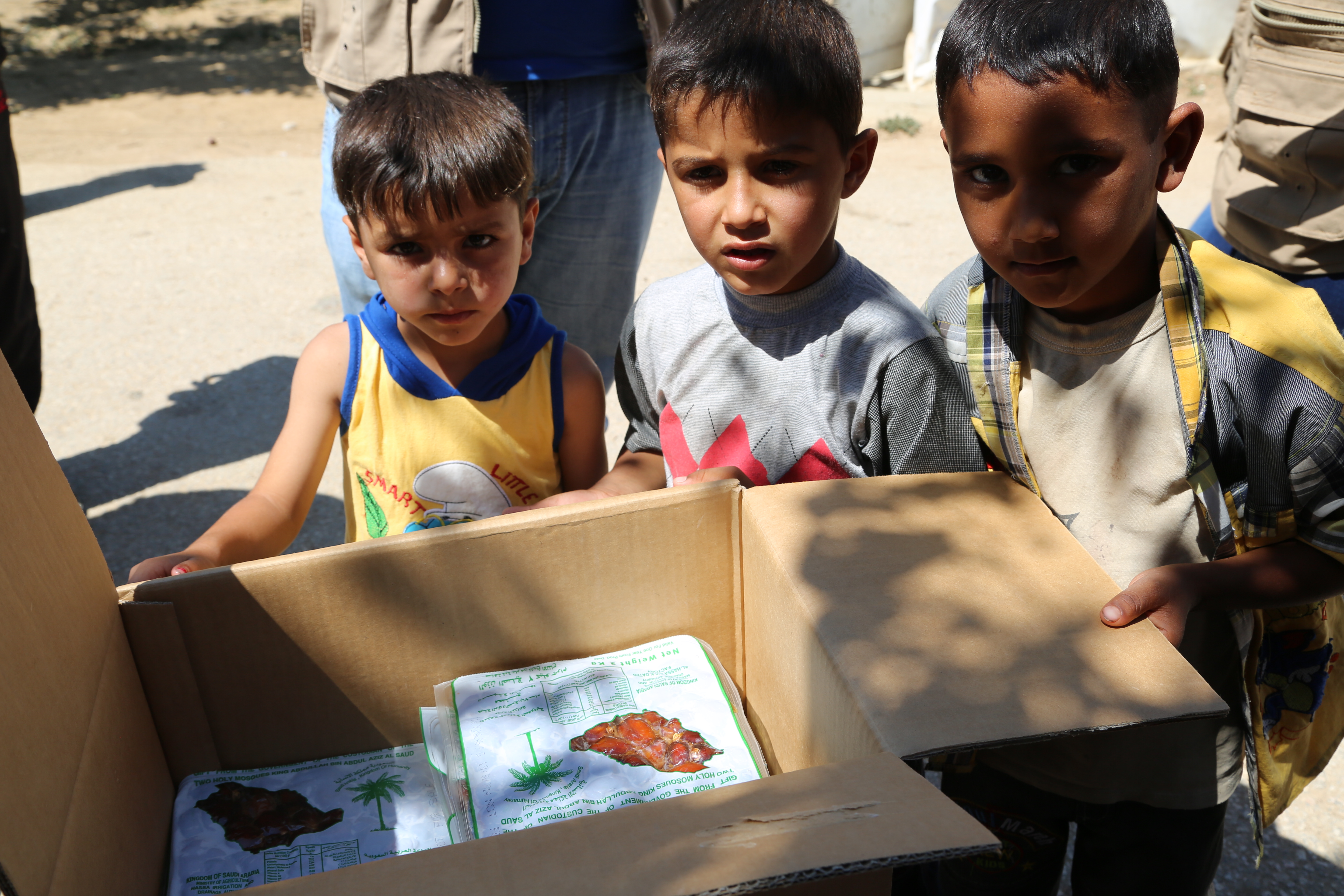 Ahmad (in yellow) and his friends with donated dates distributed by WFP in Bekaa