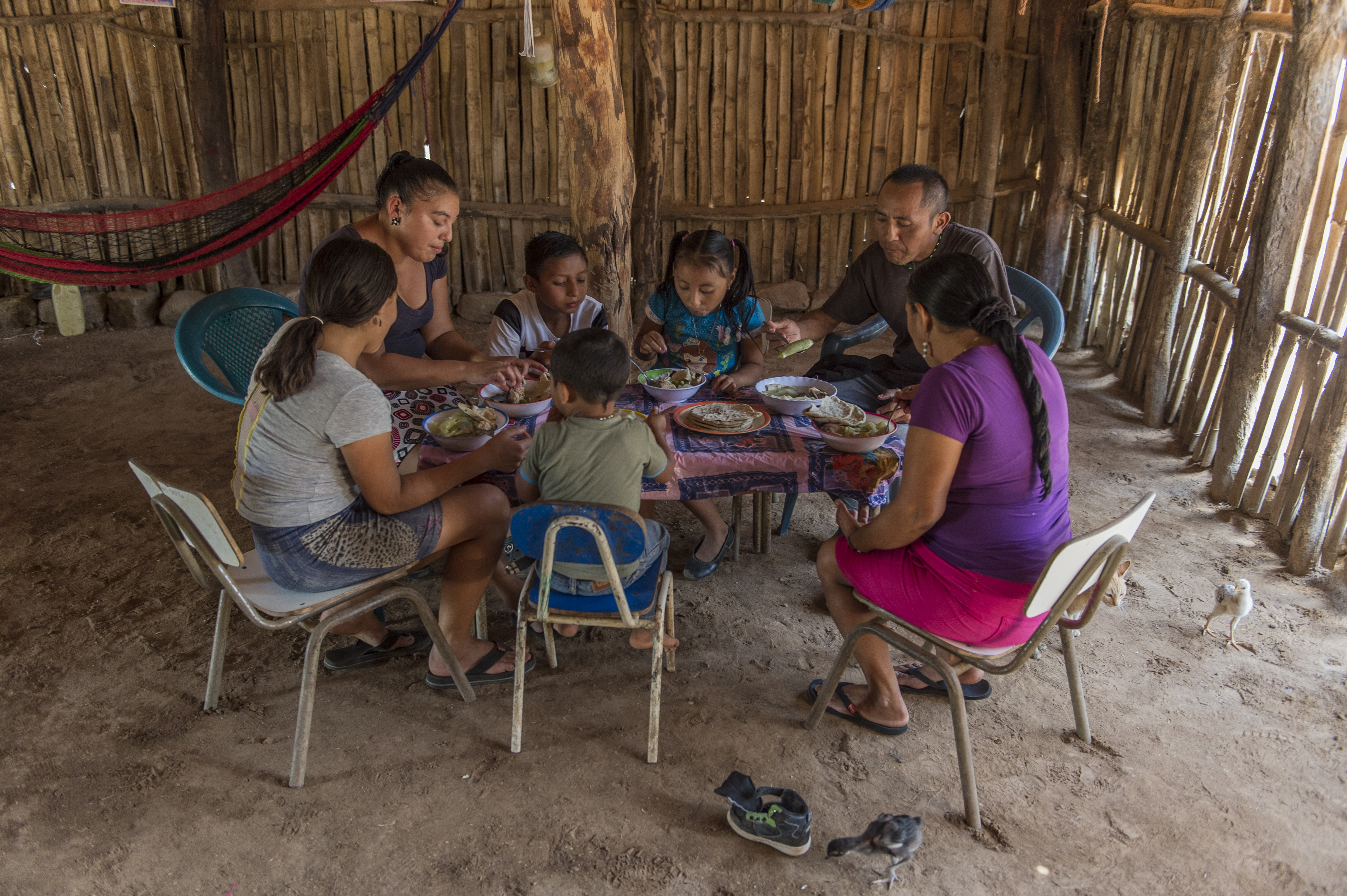 A family shares a nutritious meal of chicken soup: however, rural poverty in El Salvador often results in lack of dietary diversity.  
