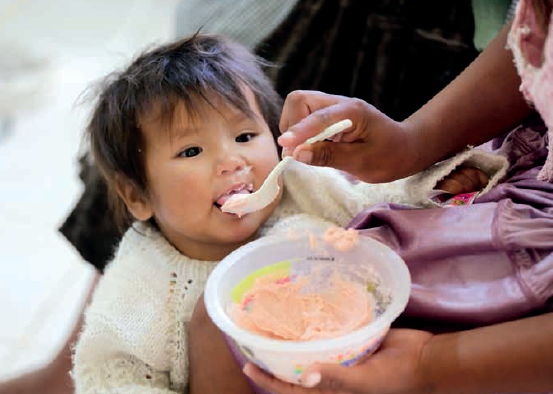 A mother in Bolivia feeds her child porridge fortified with micronutrient powders
