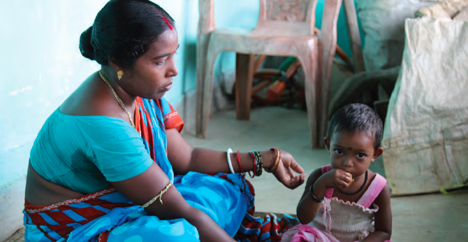 Binata Mahanta, a rural farmer in Bhandariposi Village Odisha, India, feeds her 2 year old daughter with complementary foods she learned about during a SPRING-Digital Green community video screening on infant and young child feeding practices.