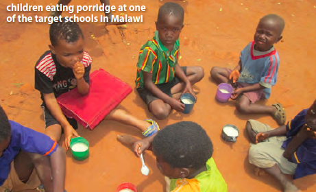 Children eating porridge at one of the target schools in Malawi