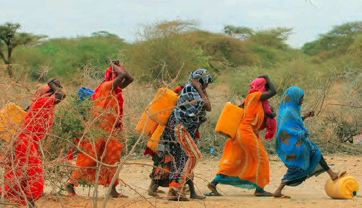 Women from Kabasa Internally Displaced People's camp return from fetching water from the river Jubba