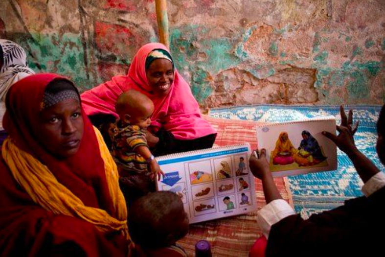 Women and young children attend a health education session at a UNICEF-supported outpatient therapeutic feeding clinic, Baidoa, Bay Region, Somalia, 2018