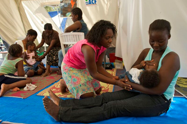 Une infirmière conseille à une mère la meilleure facon d'allaiter sa fille dans une tente "amie des bébés" en Haiti