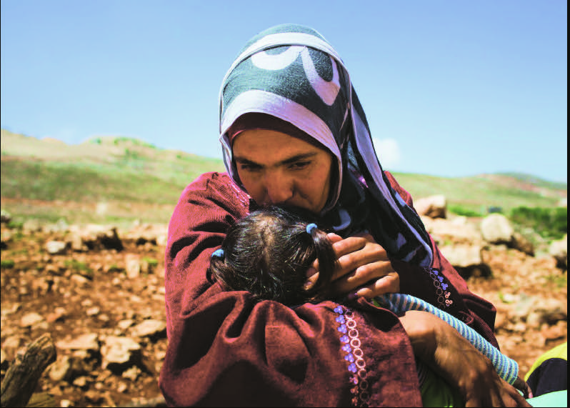 A Syrian refugee and her child arrive in Lebanon