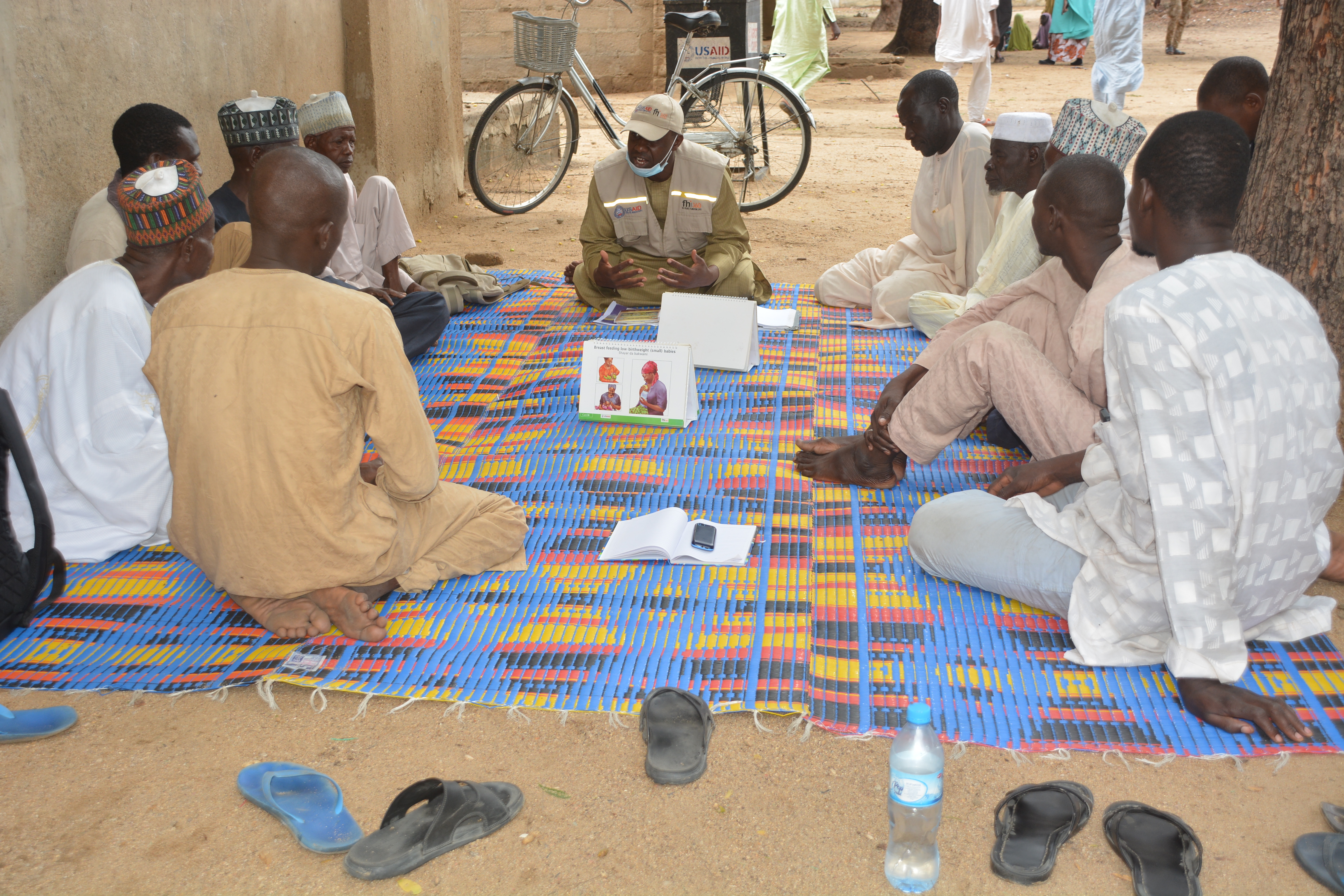 men in a group listening to man speaking using training cards
