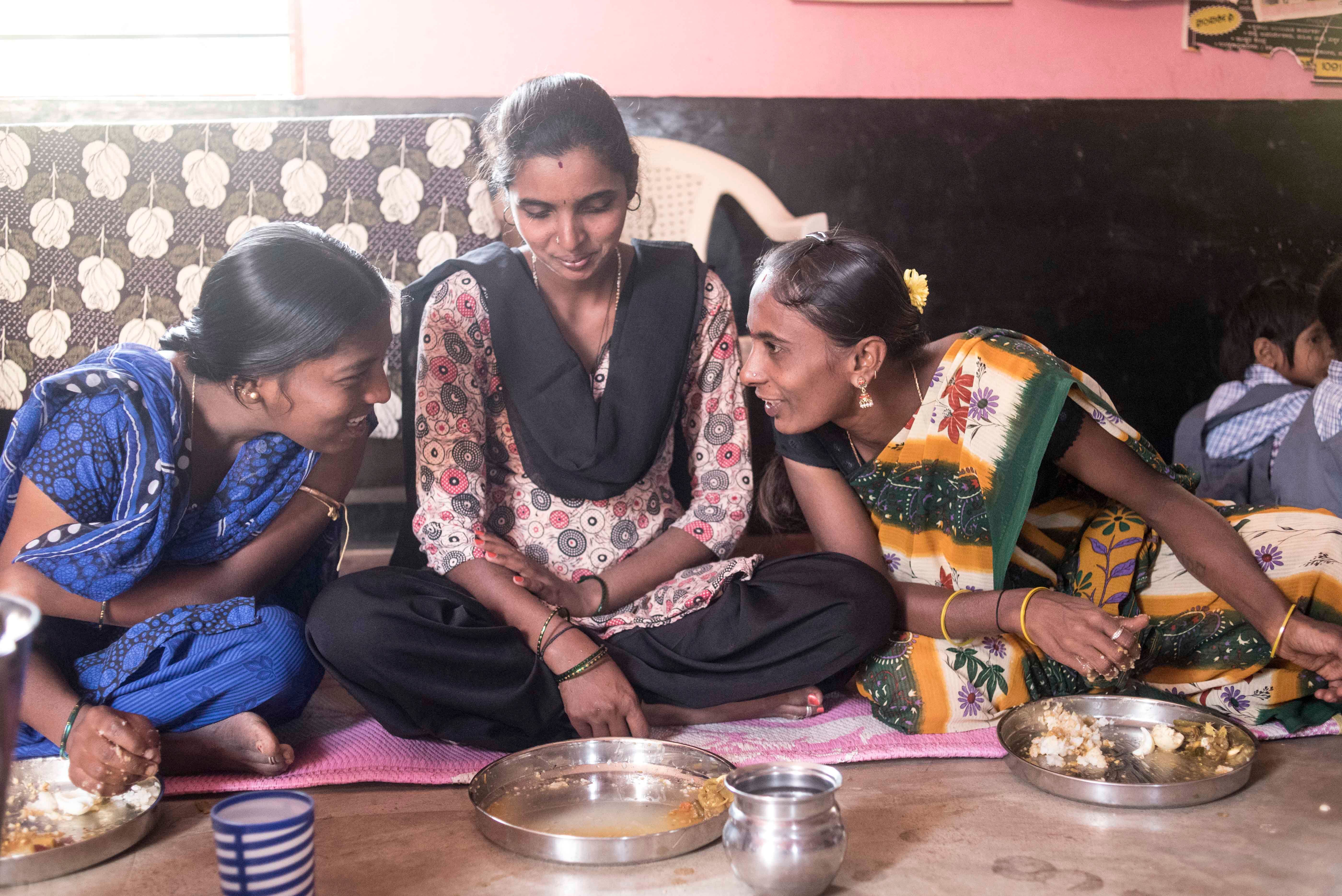 Pregnant women enjoying a hot meal and conversation in the Mathrupoorna scheme