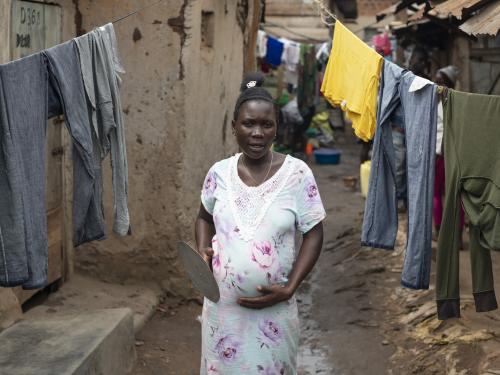 Pregnant woman in Burkina Faso standing under washing lines