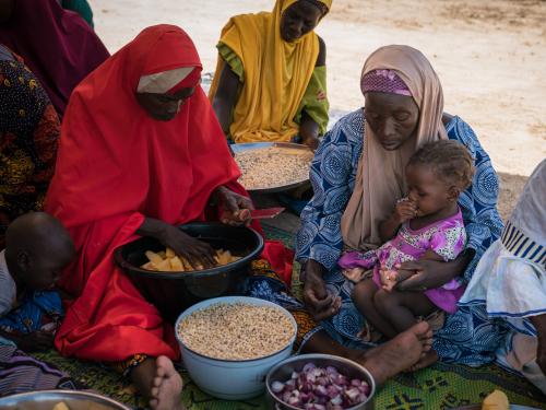 Women and children preparing a meal at a cooking demonstration in Rafa, Niger