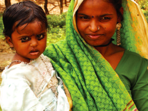 FB woman in a green sari holding a child