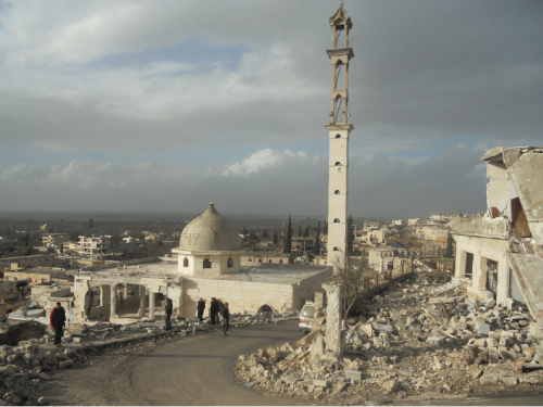 Front cover of document titled, "Programming experiences and learning from the nutrition response to the Syrian crisis." Picture shows rubble and derelict buildings in Syria.