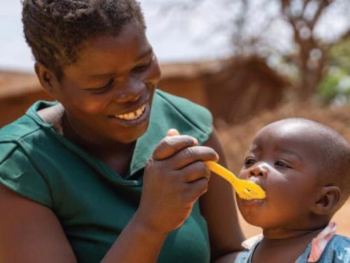 Woman spoon-feeding baby