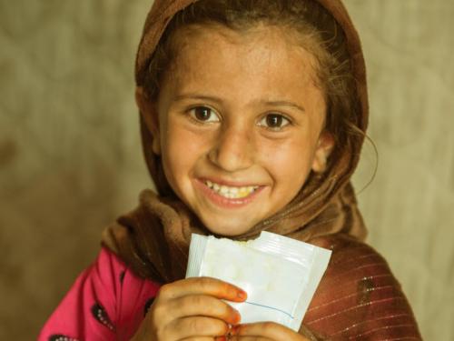 Front page of scoping study titled, "Ready-to-use Therapeutic Food (RUTF) - Scoping Study." Image shows a girl smiling and holding sachet of food.