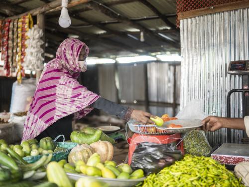 A woman preparing her fruit and vegetable store in Bangladesh.