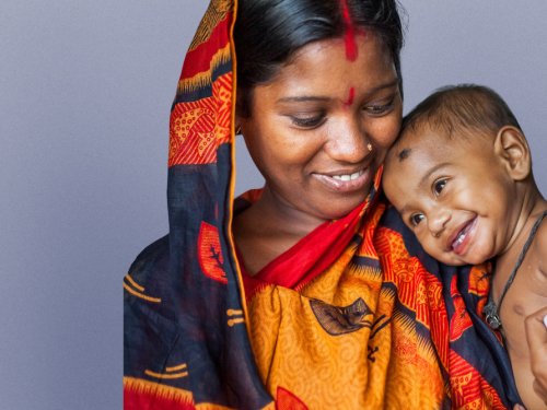 Mother holding child while their arm is being measured