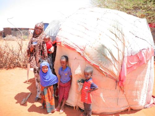 Mother with her children outside her home. Credit MoLSA