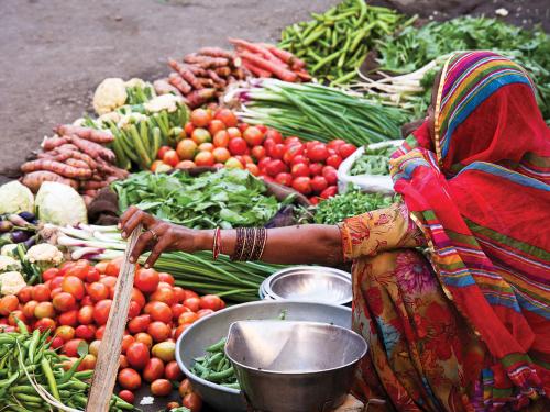 A woman in a outdoor vegetable market