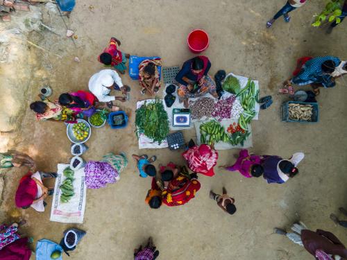 A sky view of a women selling fruit and vegetables to customers