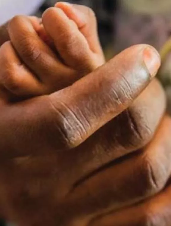 an adults' hand holding a child's hand