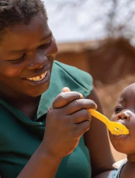 Woman spoon-feeding baby