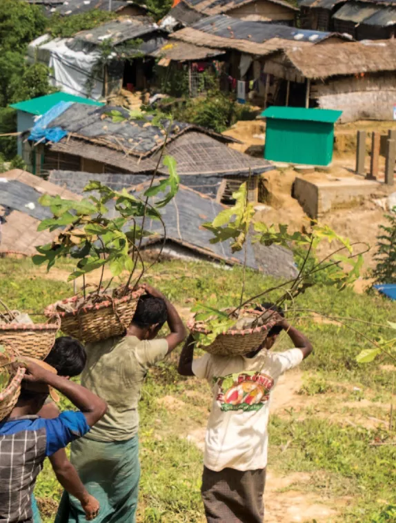 3 men carrying baskets to a vllage