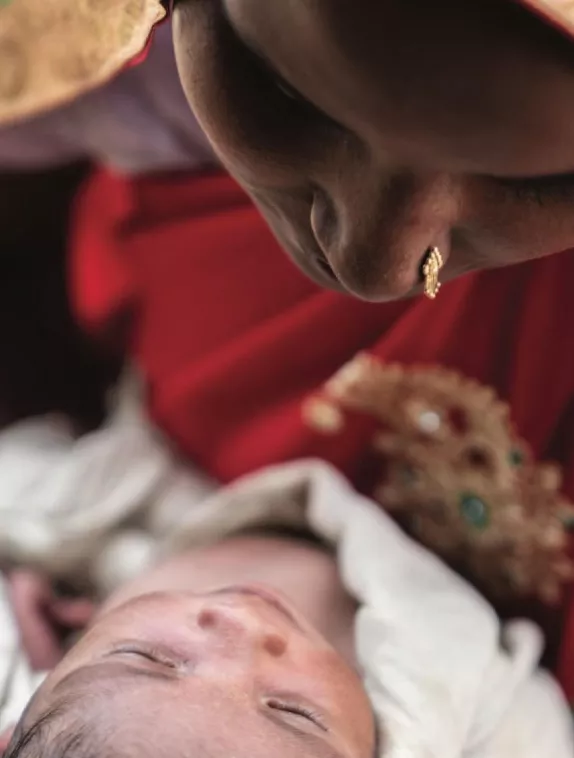 Photo of a woman in traditional Indian clothing looking at her baby