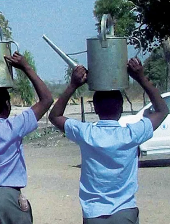 Front cover image shows two school girls carrying a watering can on their head