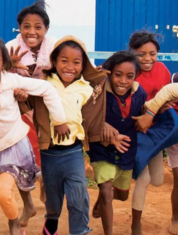 Image shows a group of children running happily towards the camera.