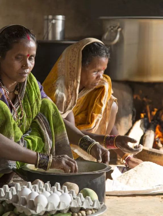 Image shows two women cooking with eggs.