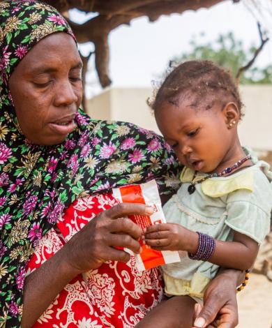 Caregivers receiving a ready-to-use therapeutic food (RUTF) sachet in Nara, Mali, 2020