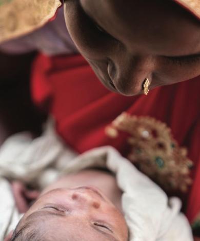 Photo of a woman in traditional Indian clothing looking at her baby