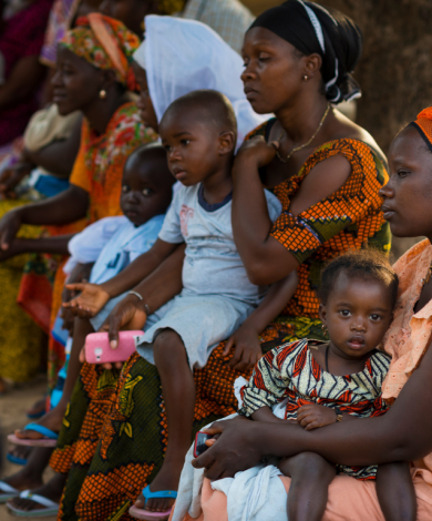 Mother and her baby daughter during a community meeting, at the Bissaque neighborhood in the city of Bissau
