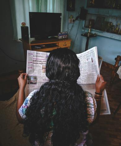 Woman reading newspaper in Kerala, India
