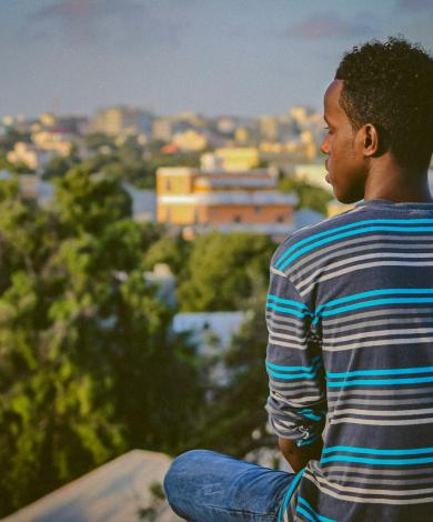 A man sitting on a ledge overlooking Mogadishu