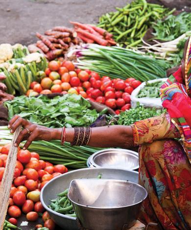 A woman in a outdoor vegetable market