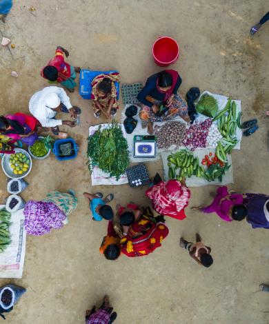 A sky view of a women selling fruit and vegetables to customers