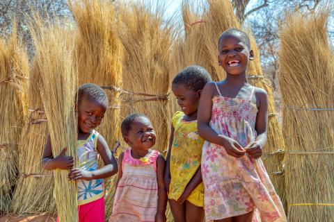 4 children smiling in a corn field