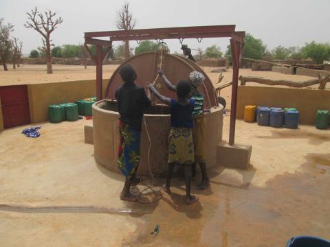 three children use a well