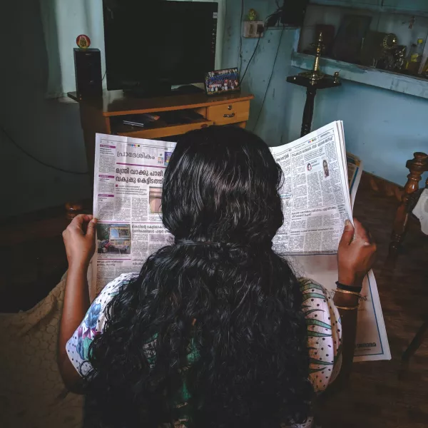 Woman reading newspaper in Kerala, India