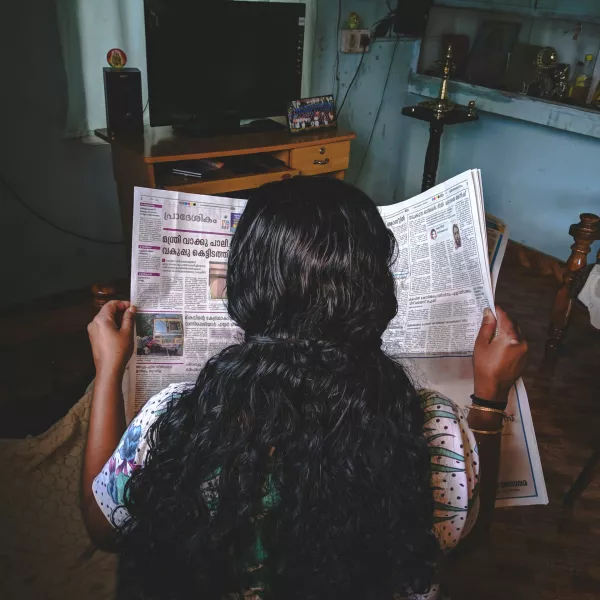 Woman reading newspaper.